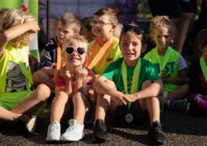 kids sitting and smiling with race medals